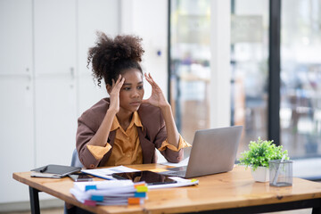 Young African American businesswoman working with pile of documents at office workplace,  feeling sick at work, stress from work, overworked, problem, unhappy.	