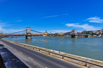 View of Szechenyi Chain Bridge over the Danube River in Budapest. It is the oldest and most famous road bridge in Budapest. View of the Danube bank in Budapest