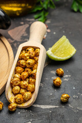 Roasted spicy chickpeas on dark table background. vertical image. top view. place for text
