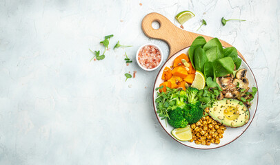 vegetable vegetarian buddha bowl avocado, mushrooms, broccoli, spinach, chickpeas, pumpkin on a light background. Long banner format. top view
