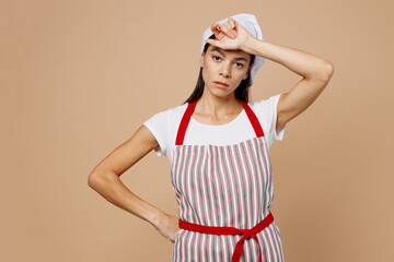 Young ill exhausted housewife housekeeper chef cook baker latin woman wear striped apron toque hat...