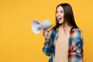 Young excited european woman wear blue shirt beige t-shirt hold in hand megaphone scream announces discounts sale Hurry up isolated on plain yellow background studio portrait People lifestyle concept