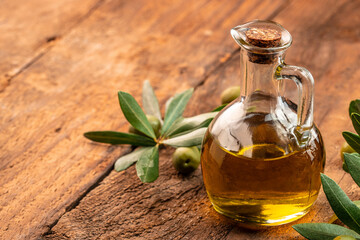 Olive oil and olive branch on a wooden background. place for text