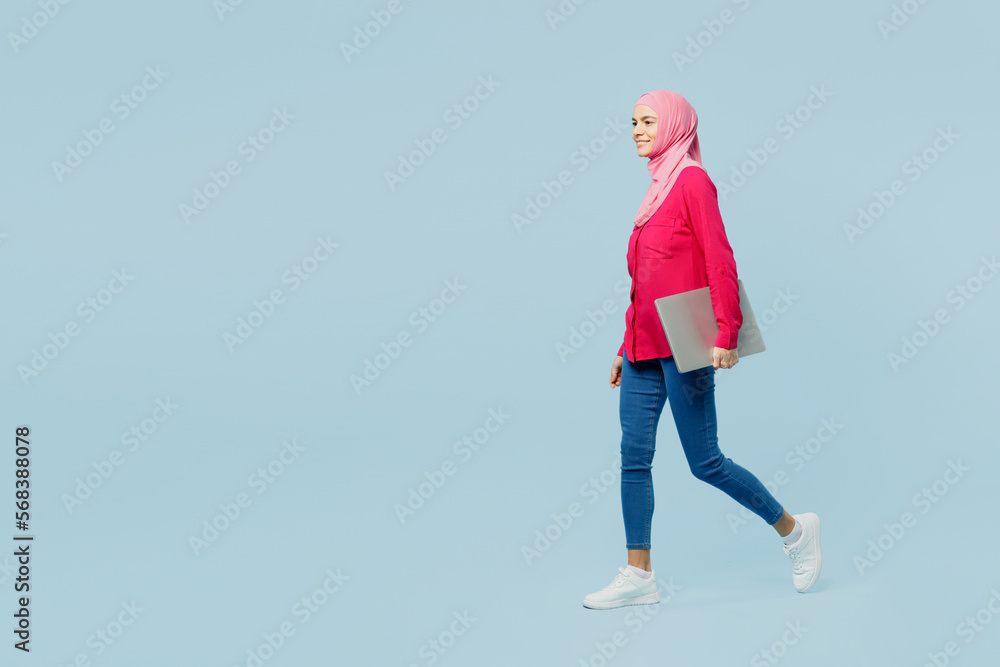 Wall mural full body fun young arabian asian muslim it woman wear pink abaya hijab hold closed laptop pc comput