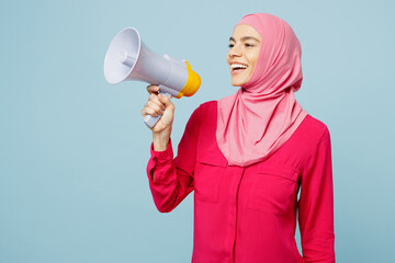 Young arabian muslim woman wear pink abaya hijab hold in hand megaphone scream announces discounts...