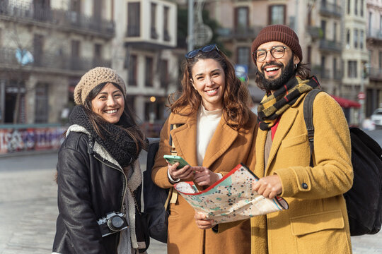Portrait of young friends visiting city during winter tourist vacations