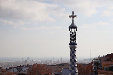 Fototapeta na wymiar Decorated cross on the top of a building in Parc Güell, Barcelona, Spain