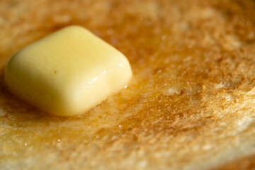 美味しいトーストの上に乗せた溶けかけたバター