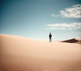 Fototapeta na wymiar Man alone in the desert, rear view, sand dunes and blue sky. AI generative