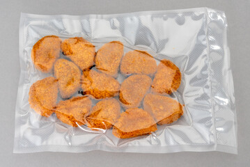 Chicken nuggets in vacuum pack for sous vide cooking on gray backgroundbackground