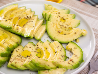 ripe avocado pulp cut into pieces sprinkled with lemon juice on a plate
