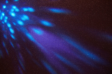 On a black fine grained background, blue and purple gradient radiance of light