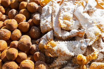 Frappe or chiacchiere and onbaked castagnole typical Italian carnival fritters dusted with powdered sugar. Biscuits with sugar for the carnival of Venice. Traditional sweet pastries of the carnival 
