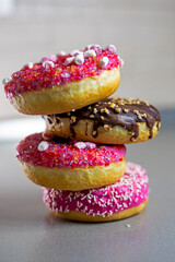 chocolate and strawberry donuts on a gray background. vertical