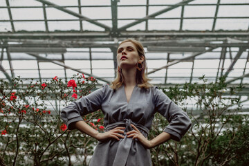 A girl poses in a botanical garden among plants