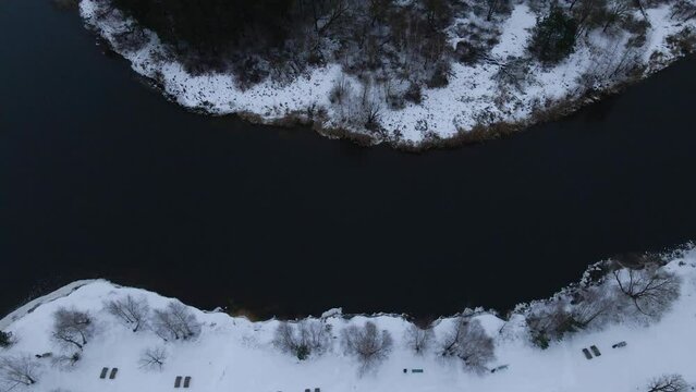 Aerial photography of an icy lake and a forest covered with snow,