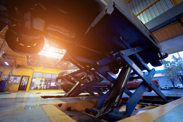 Car on hydraulic lift in auto repair shop