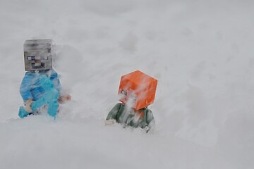 Fototapeta premium LEGO Minecraft figures of Steve with diamond sword and Alex under stream of snow in mountain avalanche. 