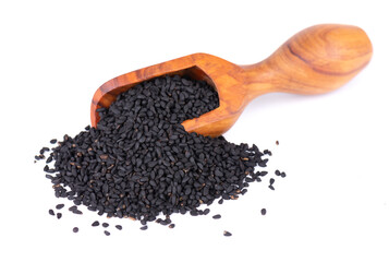Black cumin seeds in wooden spoon, isolated on white background. Heap of black nigella seeds....