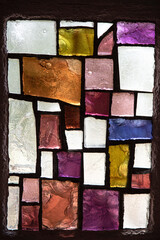 Texture of an abstract stained glass window with geometrical and coloured forms in a church