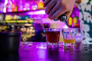 bartender hand making colorful shots
