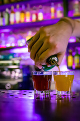 bartender hand making colorful shots