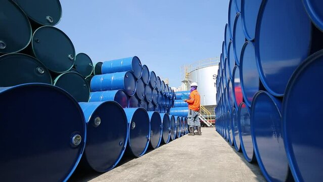 Male worker inspection record drum oil stock barrels blue horizontal or chemical for in industry.
