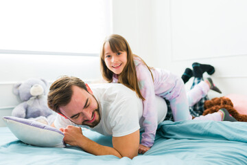 Obraz premium Fun family playing in the morning while in bed