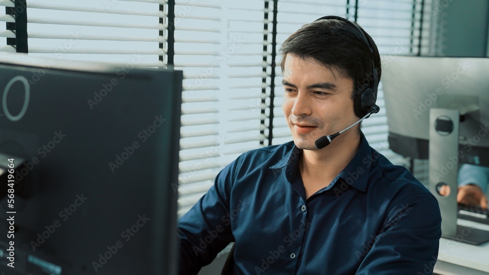 Aufkleber young competent asian male call center agent working at his computer while simultaneously speaking w