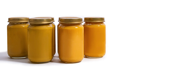 Jars of baby puree on a white background. Baby food. The first complementary food. Conservation. Banner.
