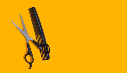 Barber scissors and a comb on a yellow background. Hair salon concept. Copy space. View from above.