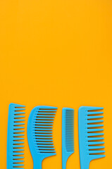 Blue combs on a yellow background. Copy space. View from above.