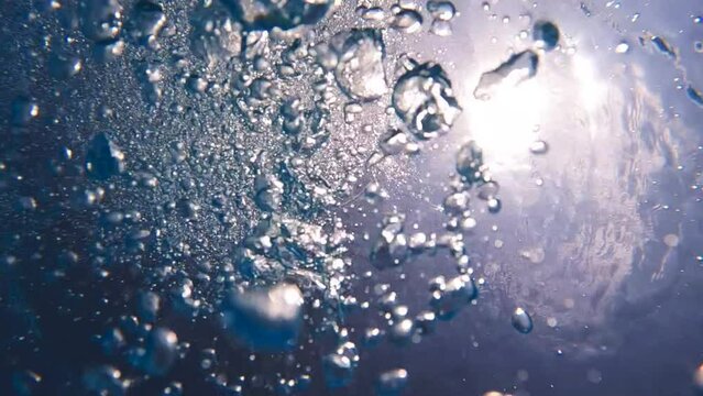 Underwater slow motion video of deep blue air bubbles released in jacuzzi spa creating perfect relaxing treatment for well being