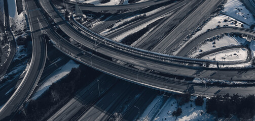 Aerial view of a freeway intersection Snow-covered in winter.Busy intersection. Birds eye view from drone. Cityscape