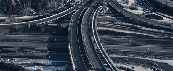 Aerial view of a freeway intersection Snow-covered in winter.Busy intersection. Birds eye view from drone. Cityscape