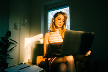 Fototapeta na wymiar Portrait of young caucasian woman college student studying with laptop, distantly preparing for test exam, writing essay doing homework at home.