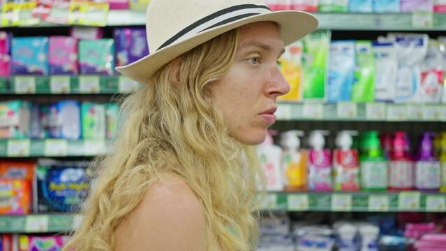 Woman Choosing Menstrual Pads On Shelf With Feminine Hygiene Products In Supermarket