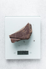 dark chocolate block for baking on a scale, Dark chocolate being weighed for baking