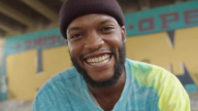 Happy african skater making hand gestures into camera
