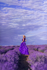 young woman in a purple dress against a beautiful sky in a field of lavender