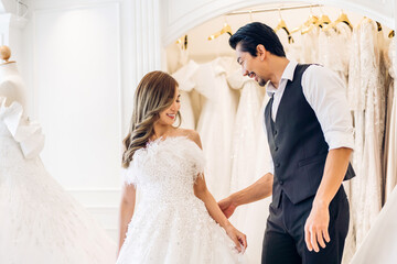 Portrait of smiling cheerful happy love asian couple fashion bride man and woman posing in white wedding dress for pre wedding hug together at wedding interior fashion studio