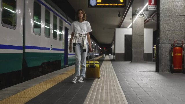 Teenage girl walks through the station to the train.