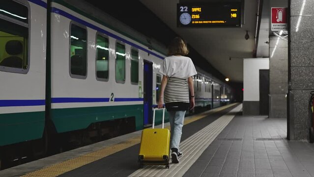 Teenage girl walks through the station to the train.
