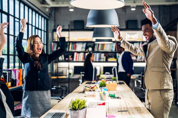Successful of happy group professional casual business people smiling and laughing to win of celebrating project success.Creative business relaxing and raising hands up in modern office