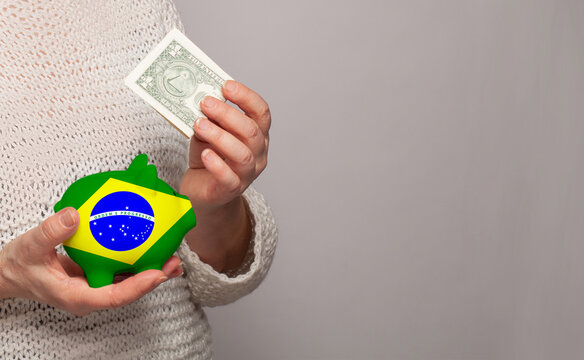 Flag of Brazil on money bank in Brazilian woman hands. Dotations, pension fund, poverty, wealth, retirement concept