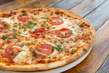 Margherita pizza or Margarita pizza on wooden background. Close up homemade fresh Italian Margherita or Margarita pizza with cheese, gourmet, basil. Pizza is traditional food for Italian on Italy.