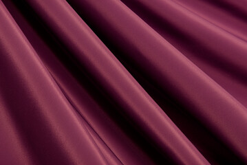 Fototapeta na wymiar Texture of a smooth luxurious, elegant fabric in burgundy, purple, red. Purple satin or silk fabric with folds and waves