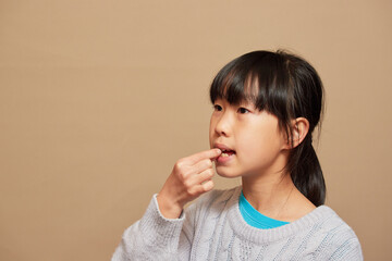 室内で薬を飲む小学生の女の子の様子