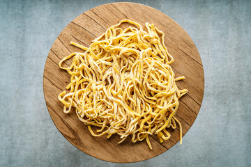 Homemade pasta. Fresh raw italian fettuccine pasta on a wooden kitchen table.