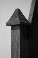 A wooden stair banister in black and white.